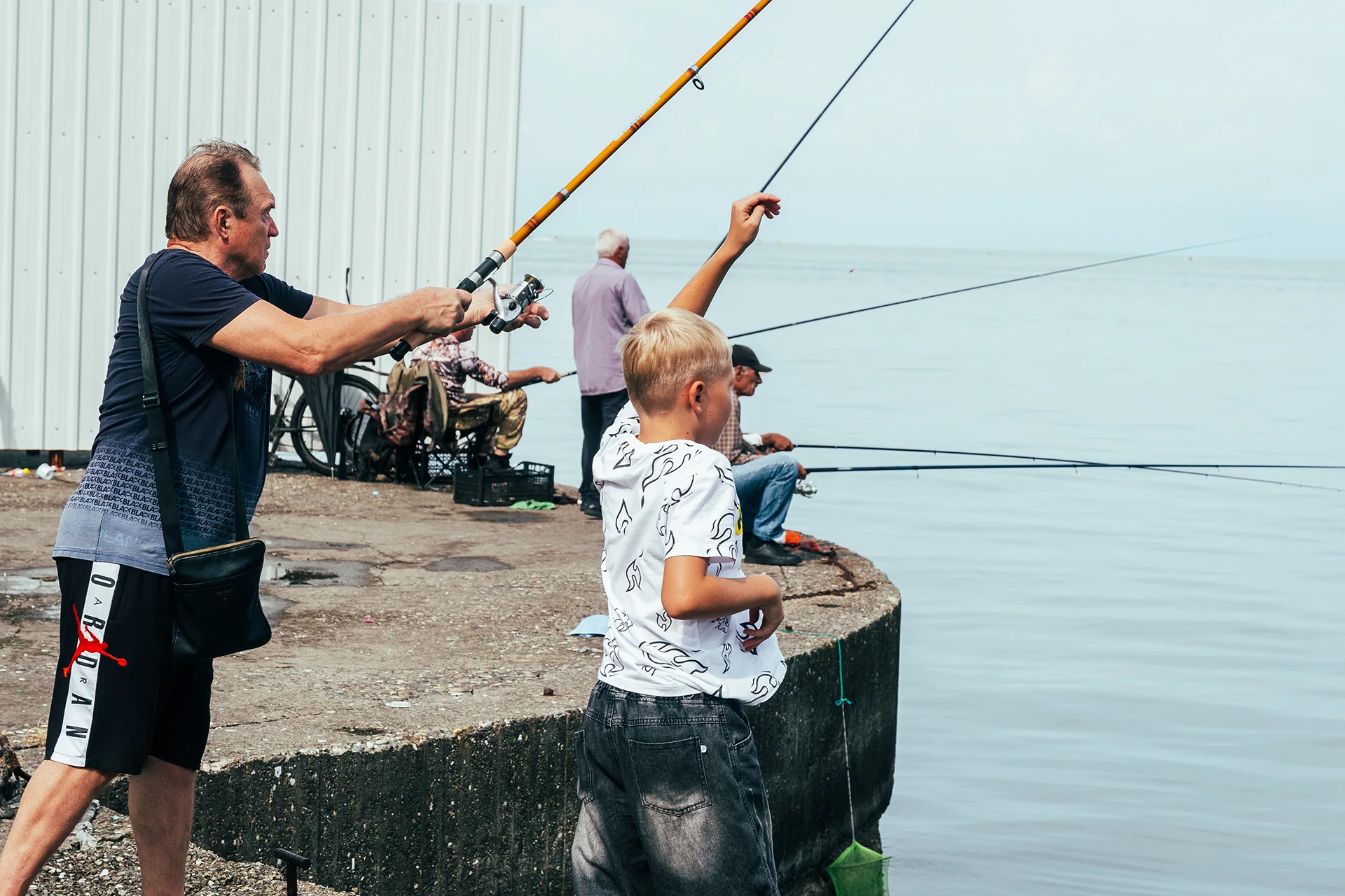 Wędkarze z długimi wędkami na nabrzeżu w Batumi