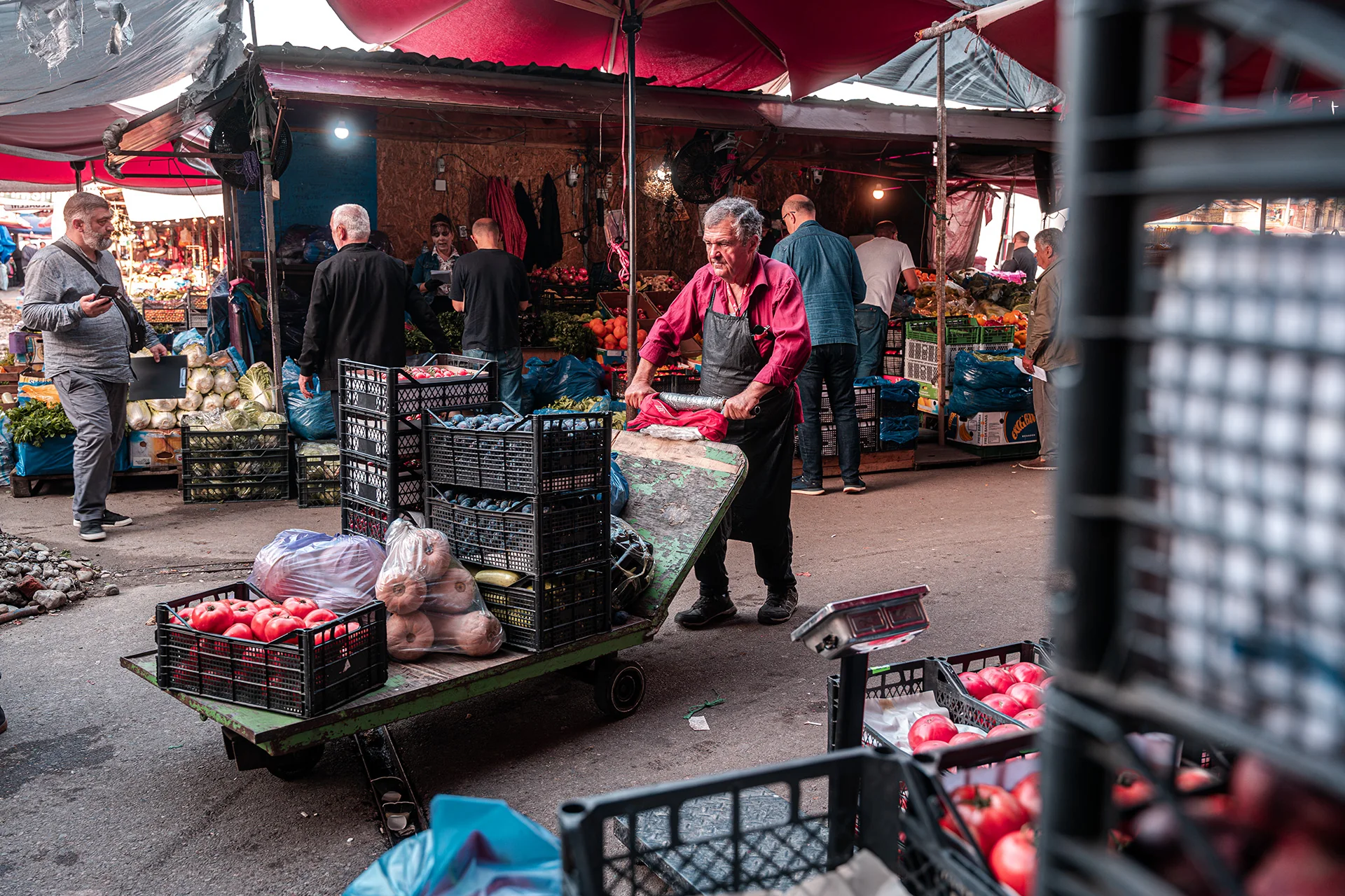 Sprzedawca z wózkiem między straganami na Dezerter Bazaar w Tbilisi