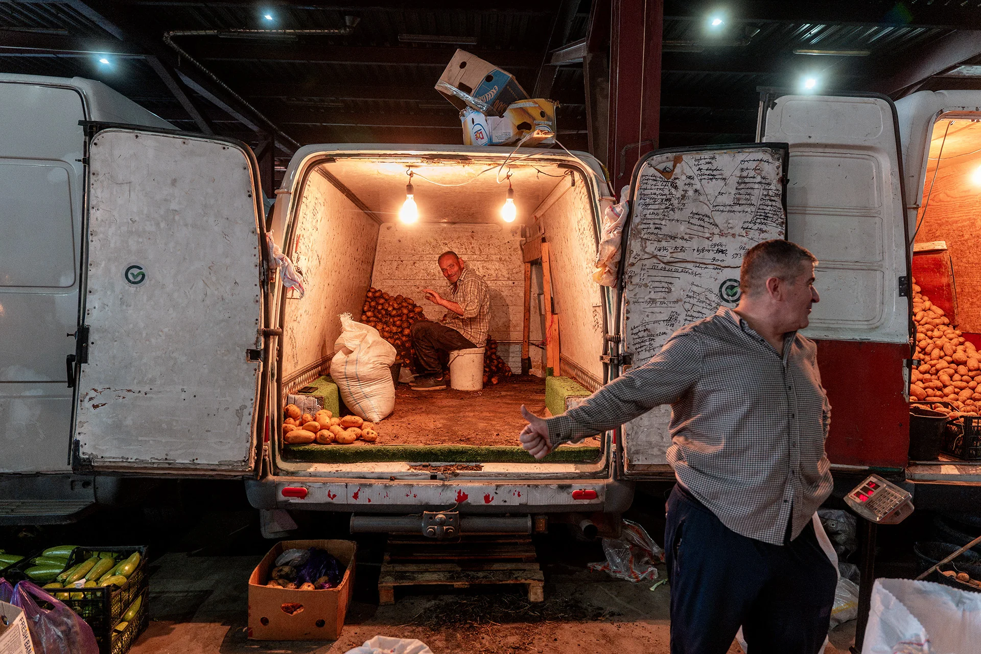 Sprzedawca przy otwartej furgonetce z towarem na Dezerter Bazaar w Tbilisi