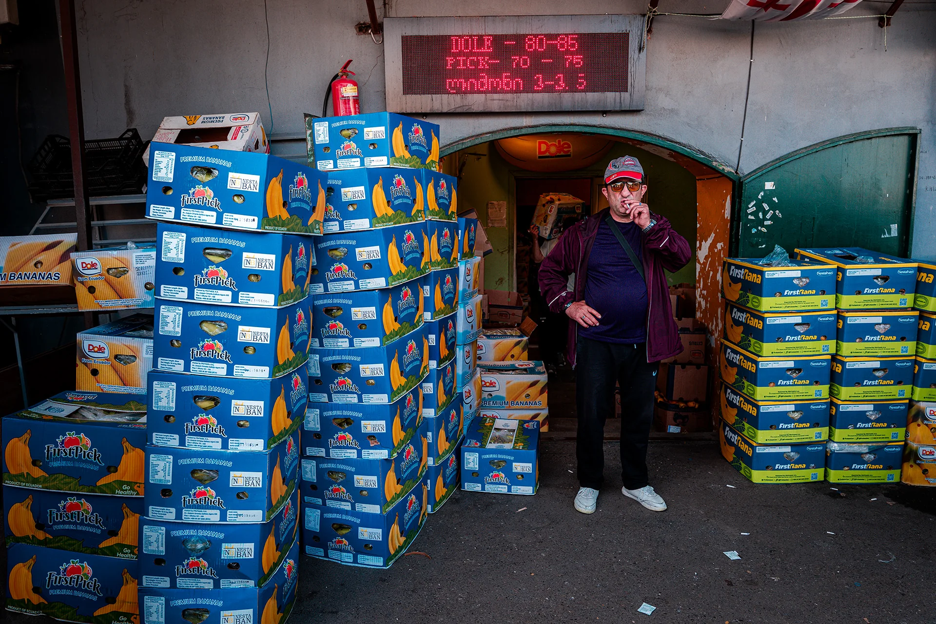 Kartony z towarem i kobieta w przejściu na Dezerter Bazaar w Tbilisi