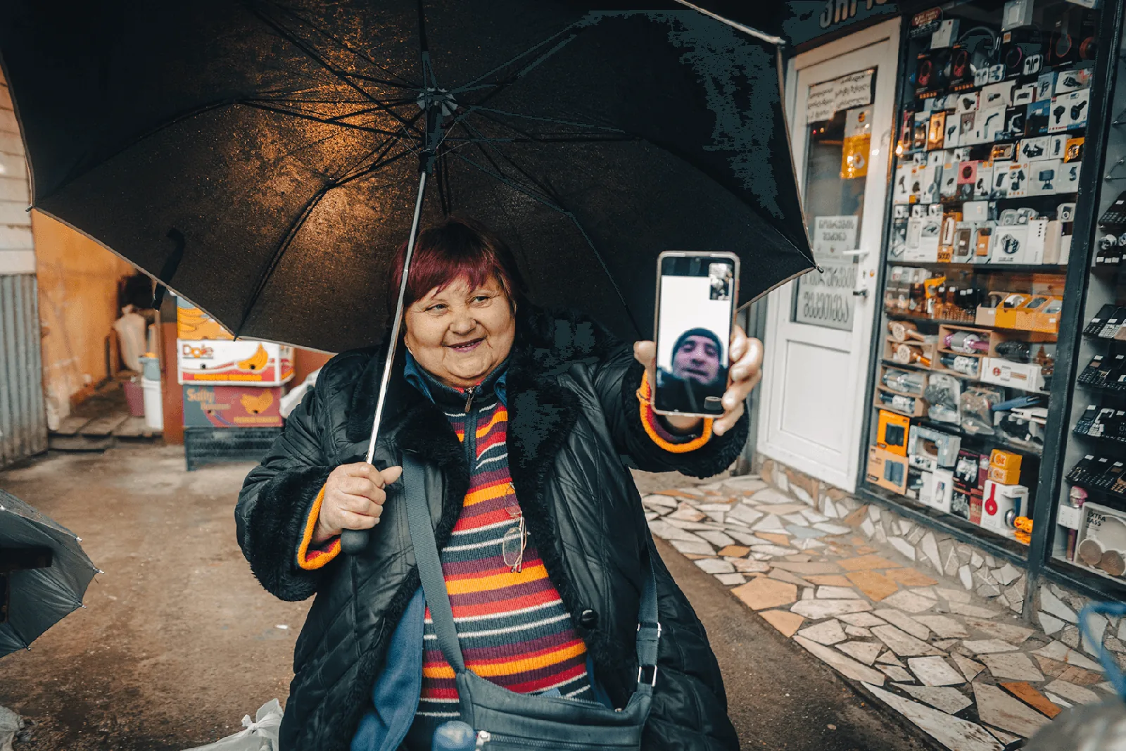 Kutaisi, kobieta na ulicy pokazuje zdjęcie na telefonie